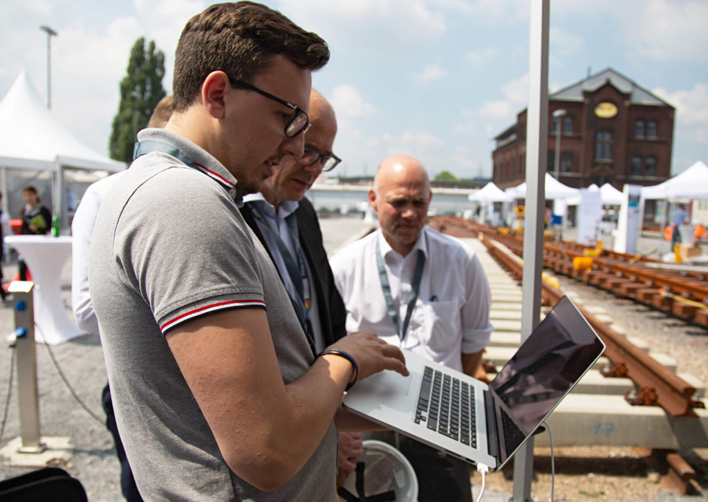 Drei Männer am Baugleis mit laptop