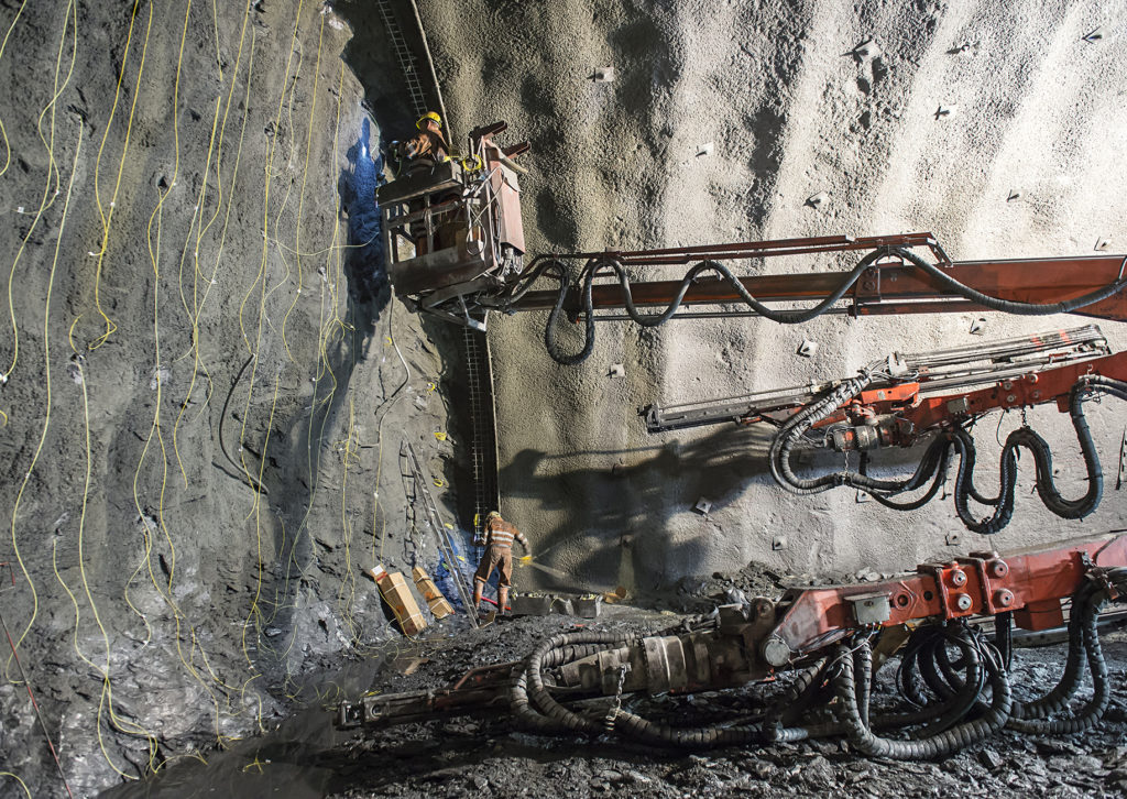 Ein Arbeiter auf einer Hebebühne vor einer Tunnelwand