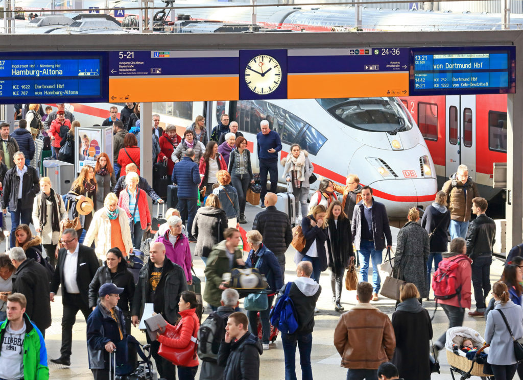 Viele Reisende an einem Bahnsteig